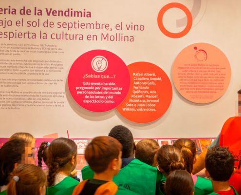 Un monitor explica a los escolares el panel de la Feria de la Vendimia de Mollina en el CIVA