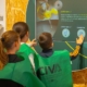 Un monitor explica a los escolares el panel de la Feria de la Vendimia de Mollina en el CIVA