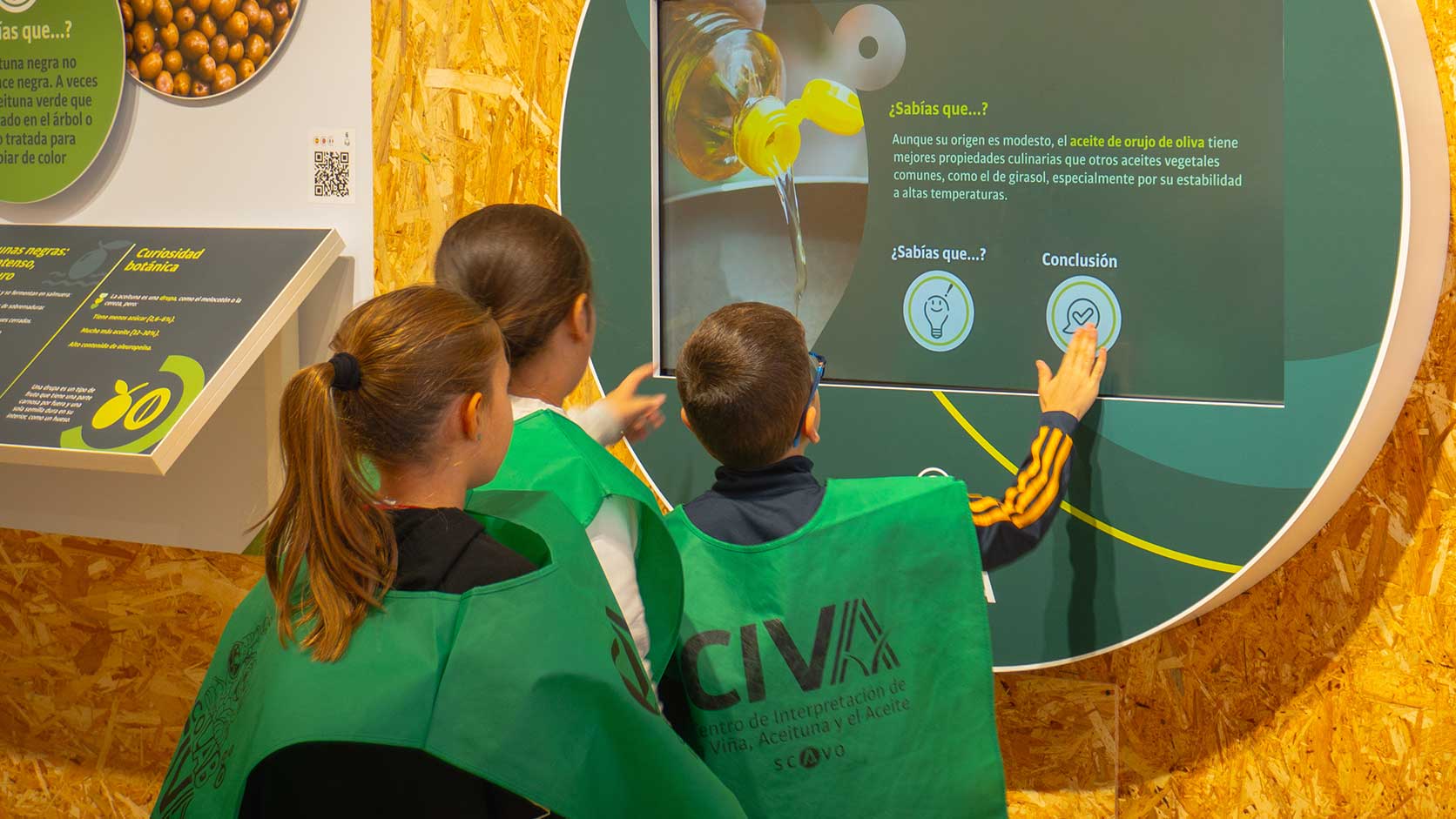 Un monitor explica a los escolares el panel de la Feria de la Vendimia de Mollina en el CIVA