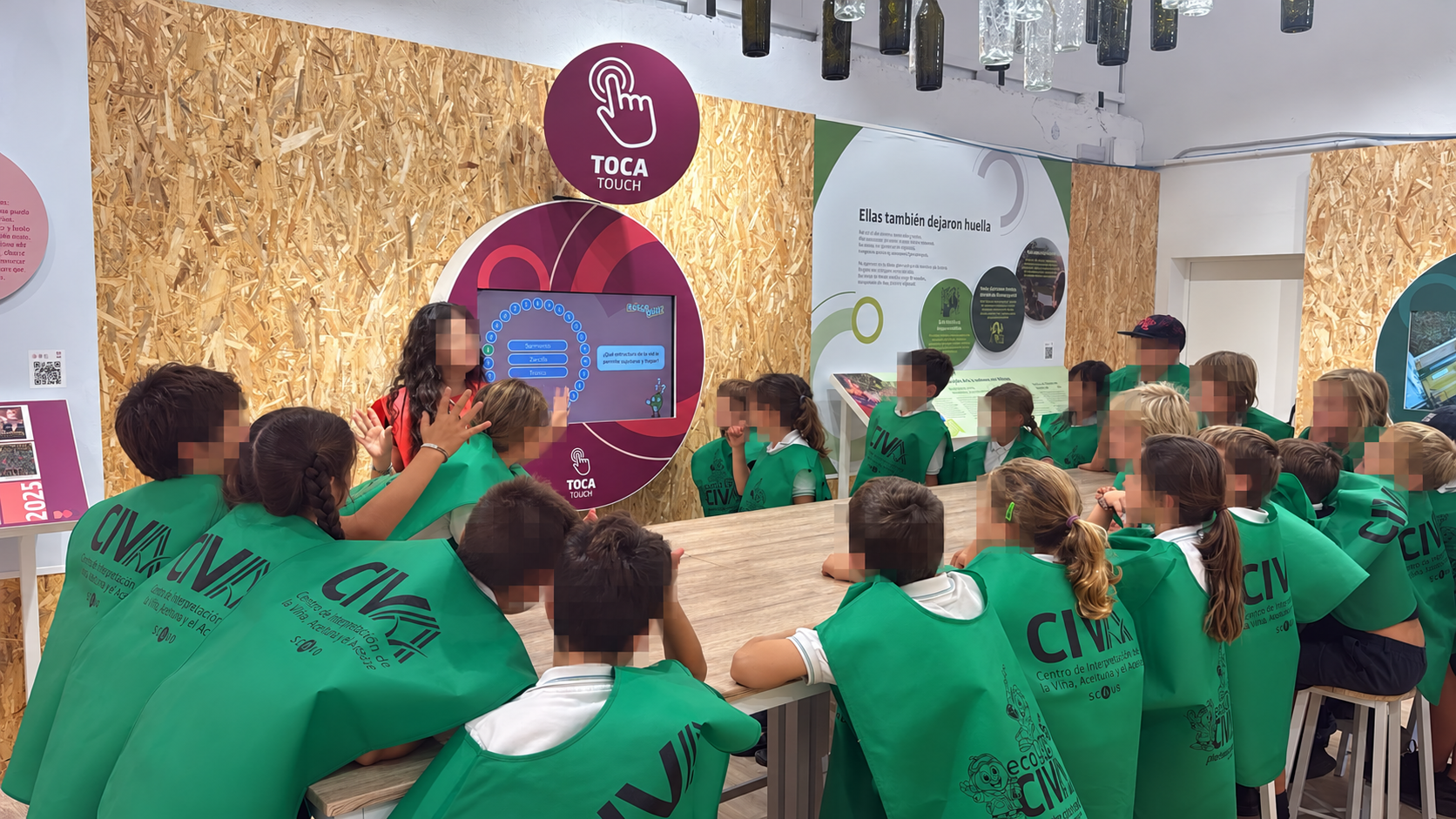 Escolares tocan una pantalla interactiva sobre el aceite de orujo de oliva en el museo interactivo del CIVA